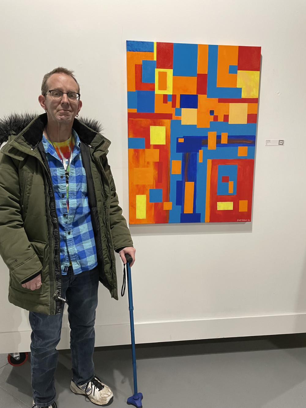Scott Olmstead at Buffalo Art Movement group show, with his artwork, "Leaning Slightly".